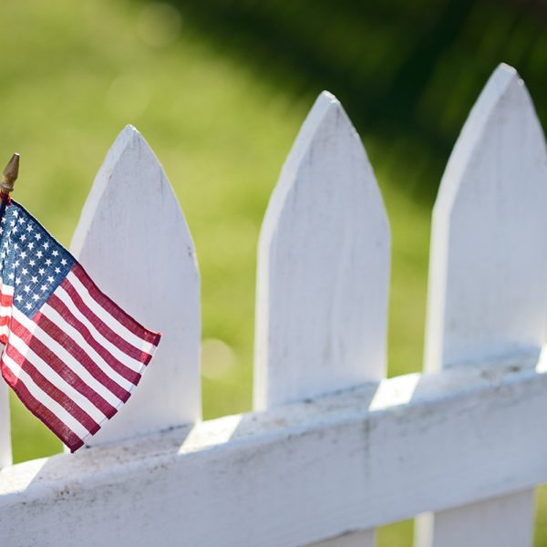 American Flag on white picket fence for Memorial Day or Labor Day.